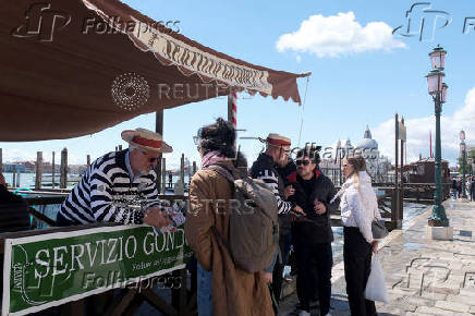 Tourists walk in St Mark's Square on the day Venice municipality introduces a new fee for day
