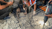 Palestinians work to rescue a child from under the rubble following an Israeli strike, amid the Israel-Hamas conflict, in Nuseirat in the central Gaza Strip