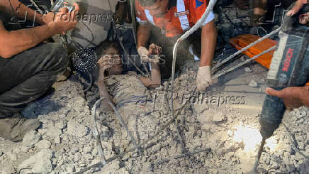 Palestinians work to rescue a child from under the rubble following an Israeli strike, amid the Israel-Hamas conflict, in Nuseirat in the central Gaza Strip