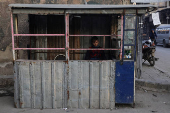 A street vendor sits beside his stall in Douma