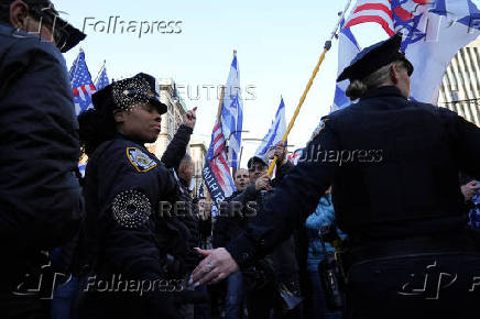 People carry American and Israeli flags as they demonstrate outside the Columbia University campus