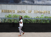 FILE PHOTO: A woman walks past the Reserve Bank of Zimbabwe building in Harare