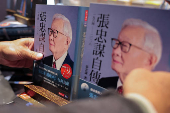 A staff adjusts TSMC's founder Morris Chang's newly released autobiography at a bookstore in Taipei,