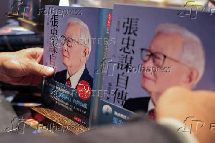 A staff adjusts TSMC's founder Morris Chang's newly released autobiography at a bookstore in Taipei,