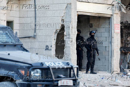 Palestinian security forces patrol amid clashes with militants at the camp in Jenin