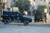 Palestinian security forces patrol amid clashes with militants at the camp in Jenin