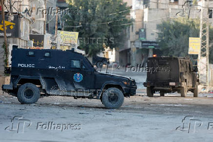 Palestinian security forces patrol amid clashes with militants at the camp in Jenin