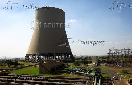 A vehicle drives past one of the cooling towers of Kendal Power Station