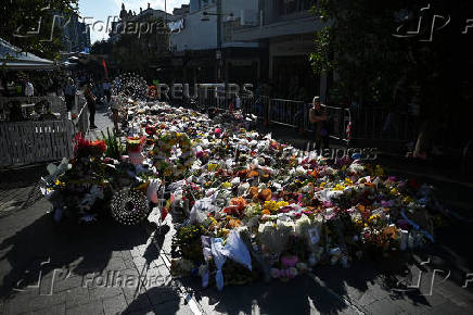 People leave floral tributes for victims of the attack at Westfield Bondi Junction shopping centre in Sydney