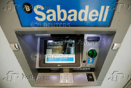 FILE PHOTO: Sabadell bank's logo is seen at an ATM machine outside an office in Barcelona, Spain