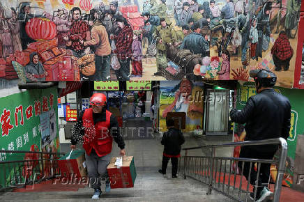 Delivery worker picks up grocery orders from a market in Beijing