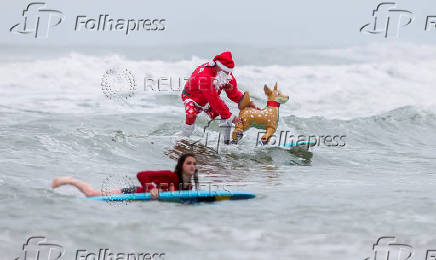 Surfing Santas take to the waves at the annual Christmas Eve event in Cocoa Beach