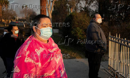 Elizabeth Jimenez stands outside the gate of her home that was destroyed by the Eaton Fire in Altadena