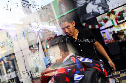 Ecuadorian immigrant Kenyi Arturo Melendez Sanchez, which had his asylum appointment canceled through the CBP One app and applied for asylum in Mexico, works in a barber shop in Tapachula