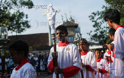 An altar boy carries a holy cross during the Holy Friday Passion of the Lord Celebrations at a church in Colombo