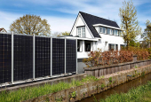 Fence made of solar panels stands along a garden in Amsterdam