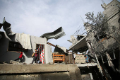 Palestinians inspect the site of an Israeli strike on a house in Rafah