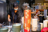 A person prepares food at a shop in Taipei