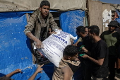 UNRWA agency hands out bags of flour to Palestinians in Khan Younis