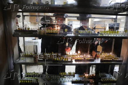 Ultra Orthodox Jews light Hanukkah holiday candles in Jerusalem