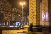 A woman listens to a street musician at night in Khreshchatyk Street in Kyiv