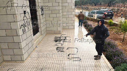 Palestinians check damage to a mosque burned by Israeli settlers in the West Bank