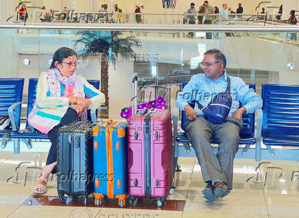 People wait for their flight at the Dubai International Airport, in Dubai