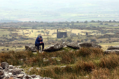 A man sits on Bodmin Moor near an old mine