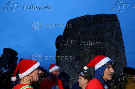 Revellers attend winter solstice celebrations during sunrise at Stonehenge stone circle near Amesbury