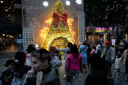 People wait to pose for pictures at a Christmas theme park in New Taipei City