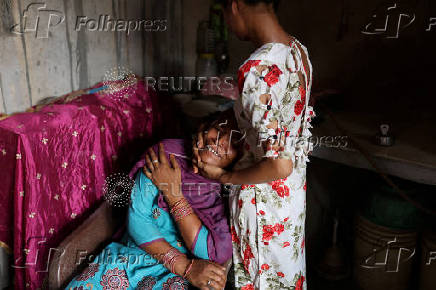 Malika breaks down as she speaks to Reuters' reporters about her husband who was killed during the Delhi 2020 riots as her daughter Khushi,17, comforts her at their residence in Loni town in the northern state of Uttar Pradesh