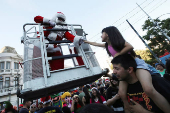 A firefighter dressed as Santa Claus greets a girl during Christmas season celebrations in Valparaiso