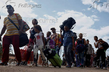 Venezuelans queue to enter a shelter after leaving Venezuela, in Pacaraima