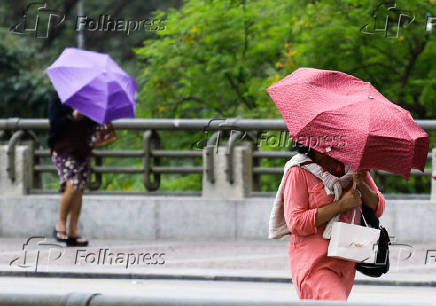 Paulistanos se protegem da chuva em So Paulo