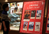 A woman looks at current movie posters including the Oscar's Best Picture winning movie 'Oppenheimer' at a movie theatre in Hiroshima