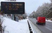 A sign displays a warning at the side of the A9 near Aviemore, Scotland