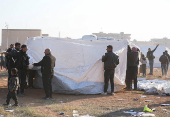 People fix tents for the displaced people who fled from Aleppo countryside, in Tabqa