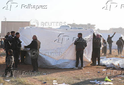 People fix tents for the displaced people who fled from Aleppo countryside, in Tabqa