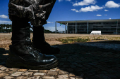 Coturnos de militar em primeiro plano, com o Palcio do Planalto ao fundo