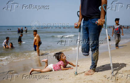 Palestinians enjoy the beach on a hot day, in Rafah