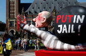 Protesters call for Russian President Putin to go to jail instead of another term in the Kremlin, in The Hague