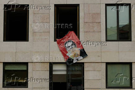 Far-right political party Chega expose banners on the facade of the Portuguese parliament against the wage reinstatement for politicians after the cuts imposed by the Troika, during the debate and vote of the 2025 budget bill on final reading, in Lisbon