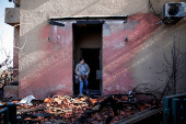 A woman inspects the damage caused by projectiles fired from Lebanon, following the ceasefire between Israel and Iran-backed group Hezbollah, in Metula