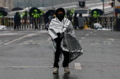 A man covers himself in a thermal blanket as he takes part in a protest against the impeached South Korean President Yoon Suk Yeol near his official residence on a snowy day in Seoul