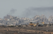 Smoke rises amidst buildings lying in ruin in the Gaza Strip, amid the ongoing conflict between Israel and Hamas, as seen from southern Israel