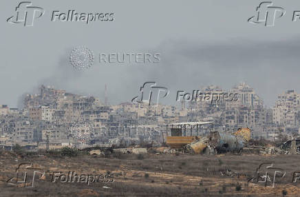 Smoke rises amidst buildings lying in ruin in the Gaza Strip, amid the ongoing conflict between Israel and Hamas, as seen from southern Israel