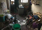 Lavanderia da casa de Guilherme, onde se acumulam roupas, jornais, baldes e ripas de madeira