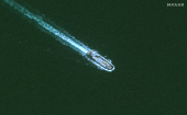 A satellite view of a ship delivering aid supplies to a floating pier on the Gaza shoreline, offshore Gaza