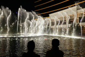 Visitors watch water fountain show outside the Wynn Macau casino resort ahead of the 25th anniversary of Macau's handover, in Macau