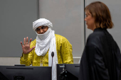 Al Hassan Ag Abdoul Aziz Ag Mohamed Ag Mahmoud greets his defense team, with main defense counsel Melinda Taylor, in the courtroom of the International Criminal Court in The Hague